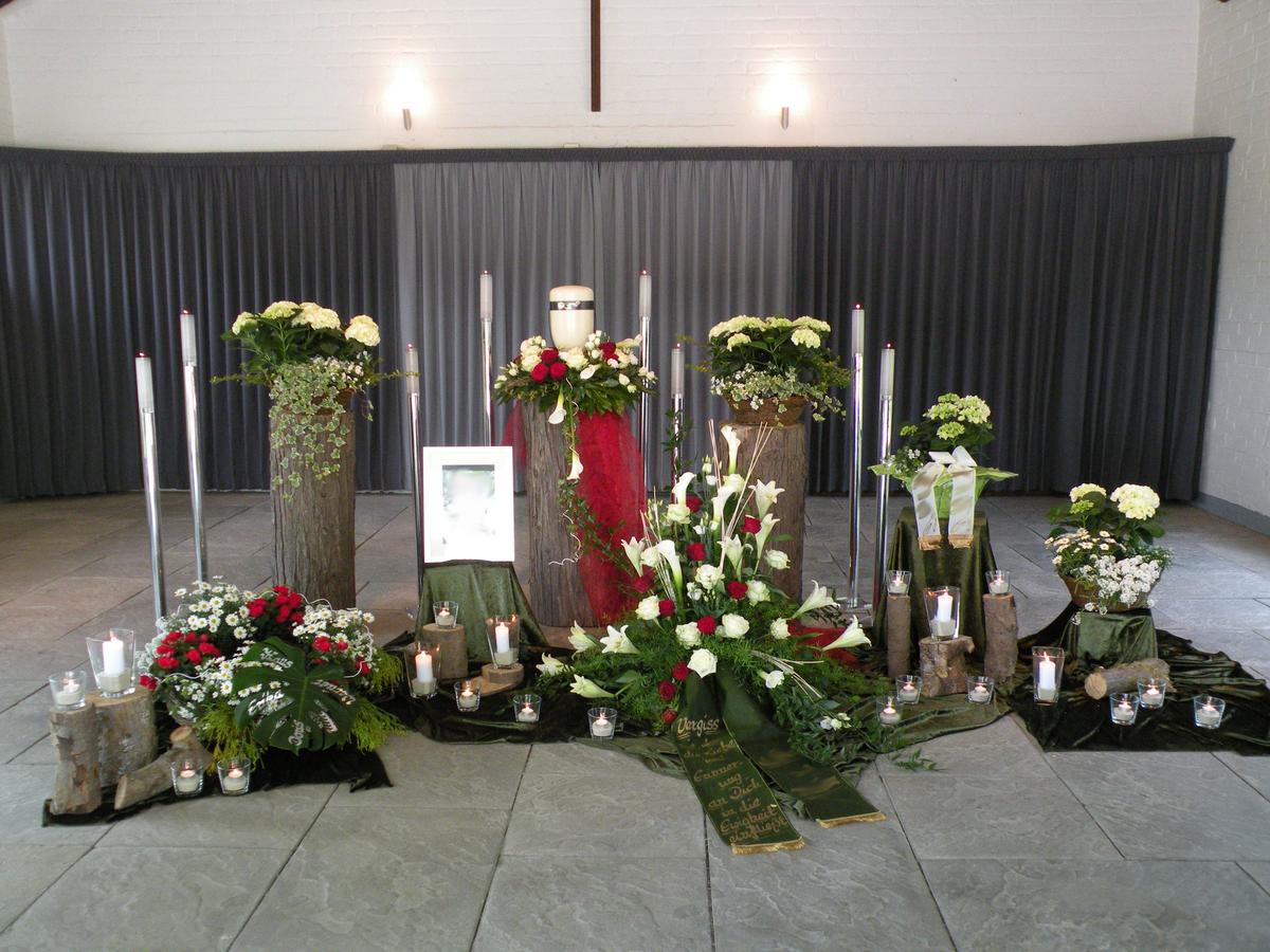 Urnendekoration in der Trauerhalle Dorffriedhof Seelscheid mit Baumstämmen