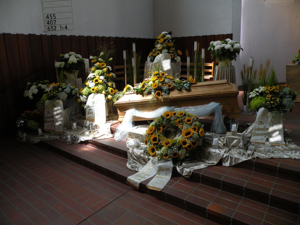 Dekoration einer Trauerfeier mit Sarg in gelb weiß
